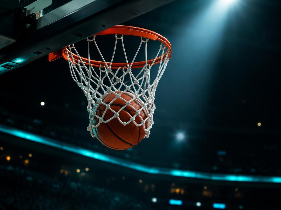 Basketball dropping through the hoop in a dark arena